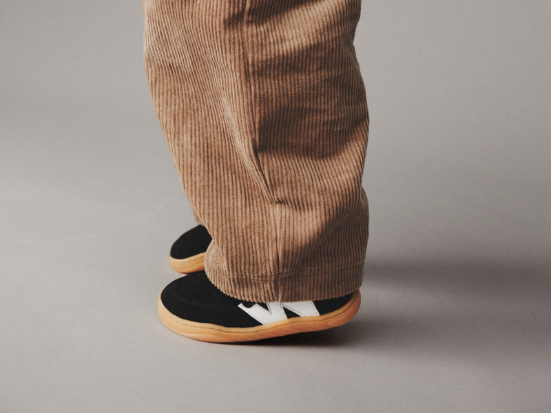 barn med sorte sneakers