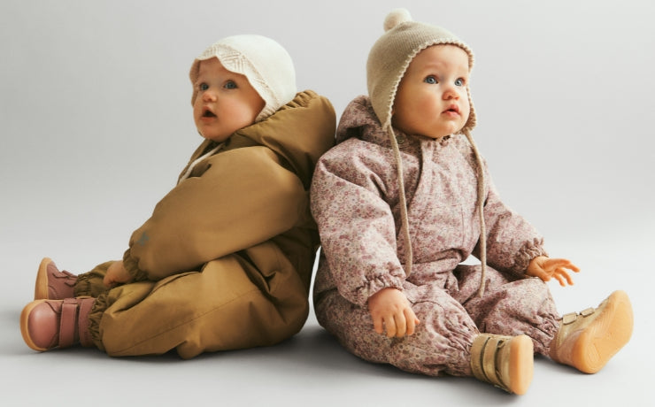 2 babyer i flyverdragter og strik huer 